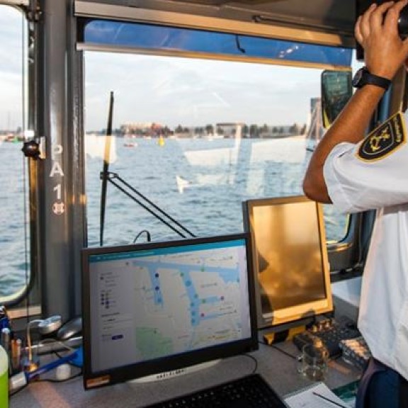 Schipper met computer met hierop de nieuwe arrivals app