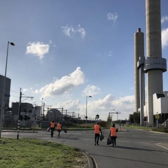 collega's port of Amsterdam die op een haventerrein zwerfvuil opruimen