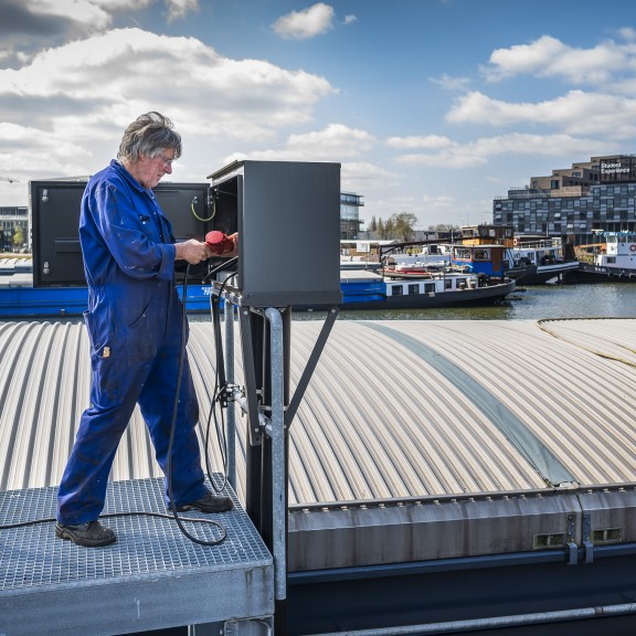 Binnenvaartschipper sluit walstroom aan