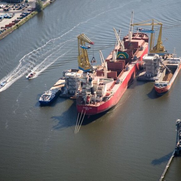 Een tal schepen die zich bevinden bij de Mercuriushaven in de buurt. Er wordt gewerkt met kranen om een boot te ontladen van haar vracht. 