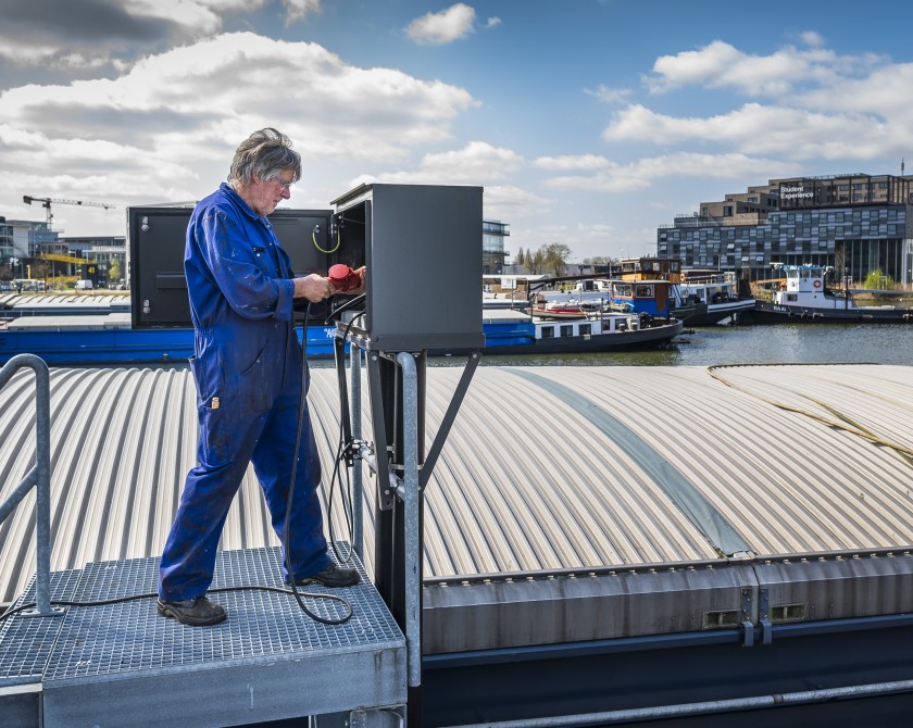 Binnenvaartschipper sluit walstroom aan