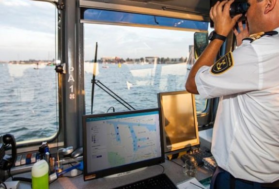 Schipper met computer met hierop de nieuwe arrivals app