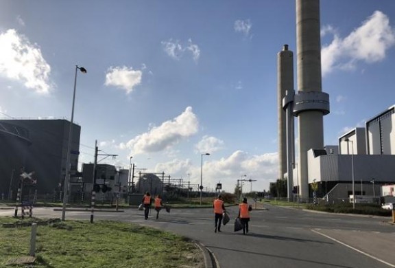 collega's port of Amsterdam die op een haventerrein zwerfvuil opruimen