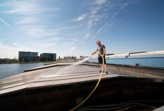 Binnenvaartschipper spuit dek schip schoon