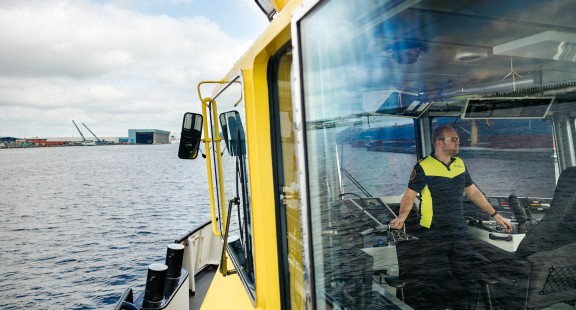 Havenbeambte aan boord van patrouillevaartuig