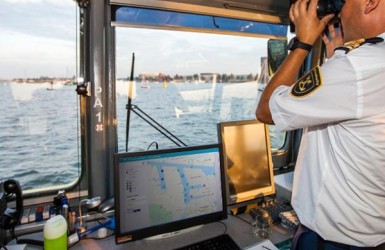 Schipper met computer met hierop de nieuwe arrivals app