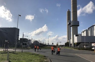 collega's port of Amsterdam die op een haventerrein zwerfvuil opruimen
