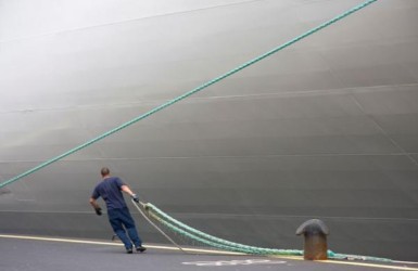 havenwerker legt schip aan kade en bolder aan