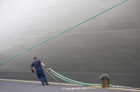havenwerker legt schip aan kade en bolder aan
